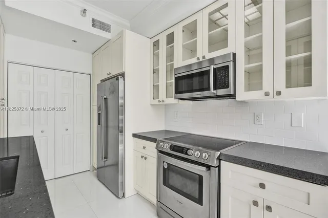 a kitchen with stainless steel appliances granite countertop a stove and a refrigerator
