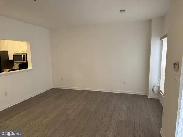 a view of a room with wooden floor and a window
