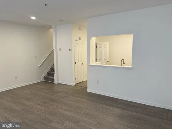 an empty room with wooden floor and cabinet
