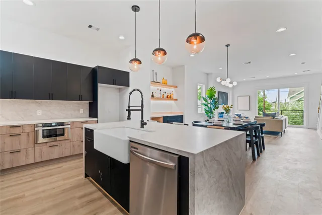 a kitchen with a stove a kitchen island a dining table and chairs with wooden floor