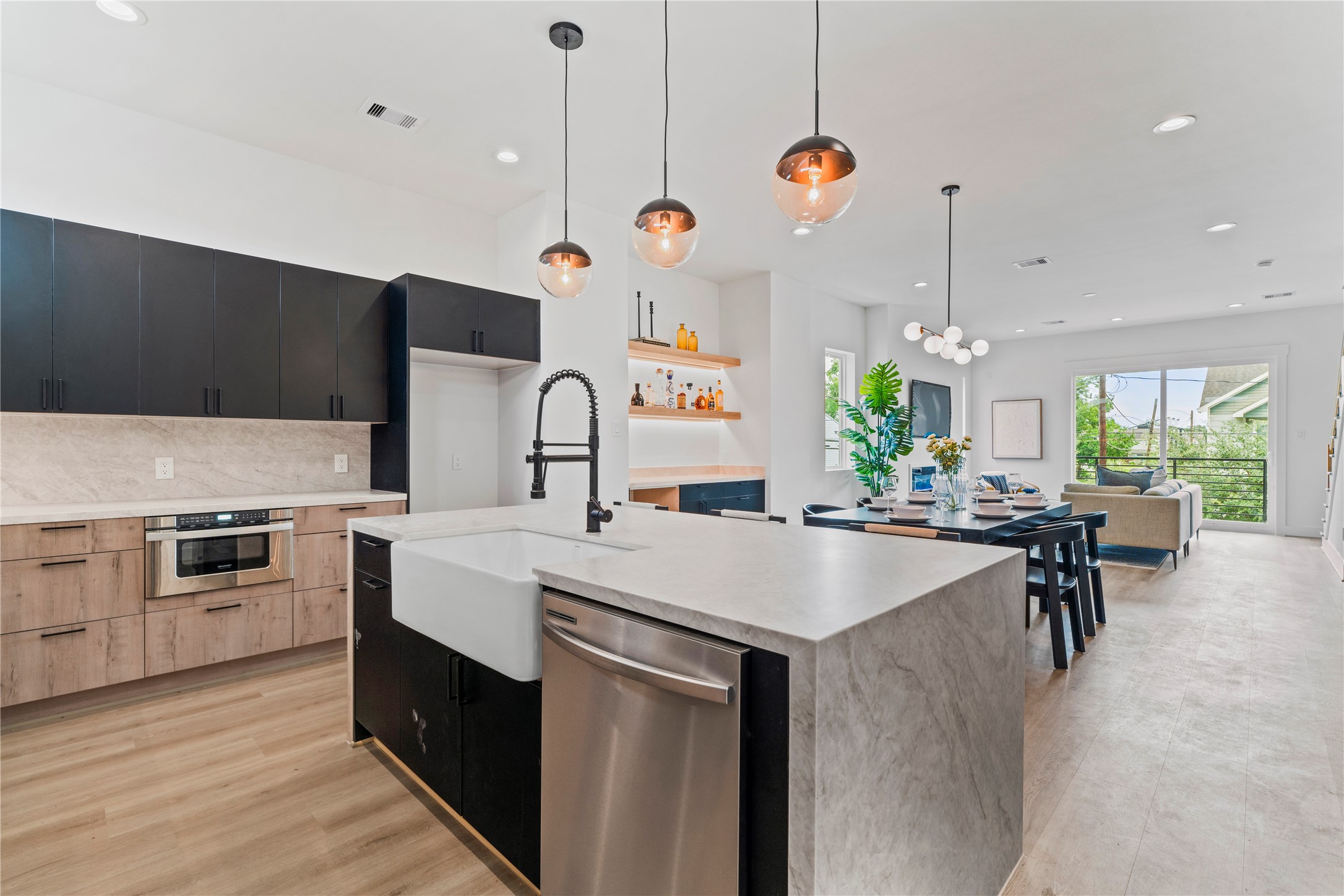 4436 Oats Street Houston, TX 77020 - Photo 18 of 37 a kitchen with a stove a kitchen island a dining table and chairs with wooden floor
