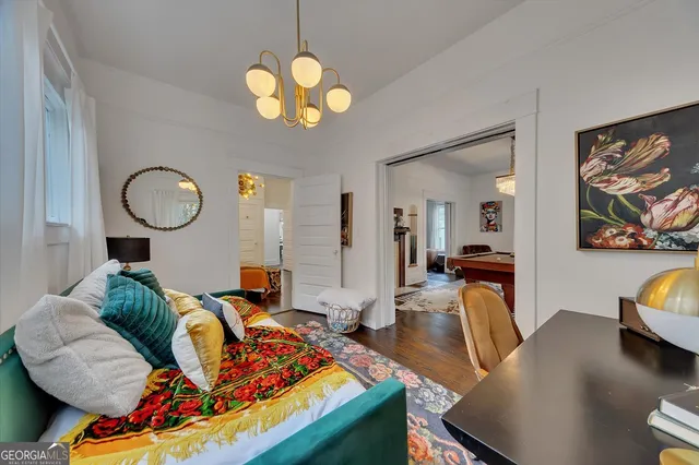 a living room with furniture chandelier and a view of kitchen