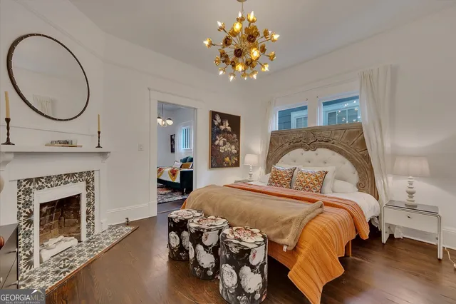 a bedroom with a bed mirror and a fireplace