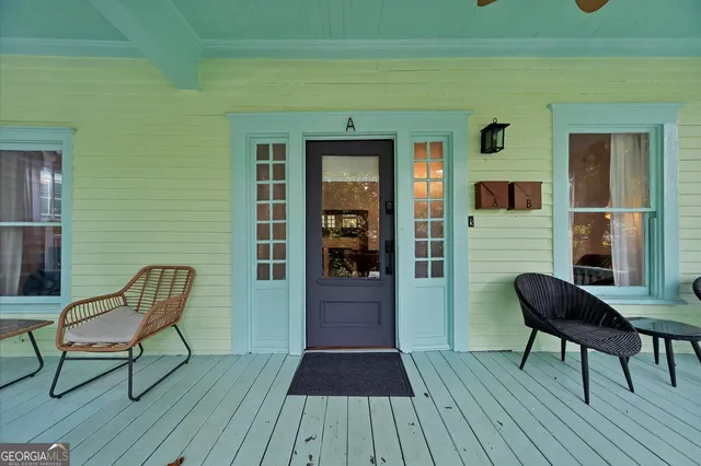a view of a house with a chairs and table on the wooden floor