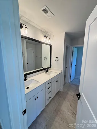 a spacious bathroom with a double vanity sink and mirror