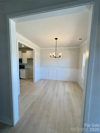 a view of an empty room and kitchen view