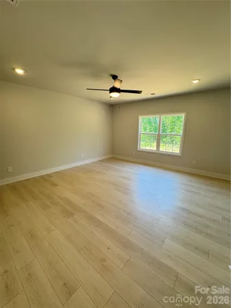 an empty room with windows and ceiling fan view