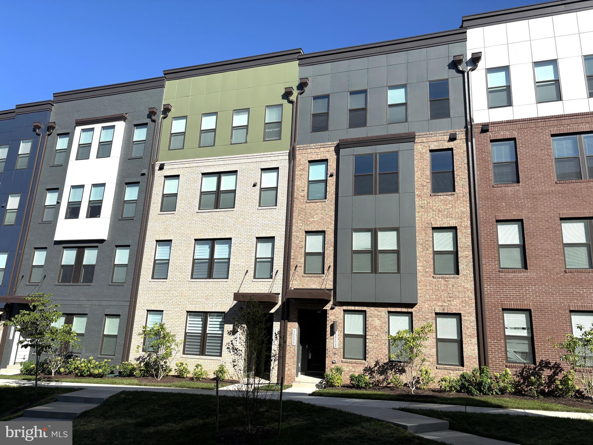 a front view of a residential apartment building with a yard