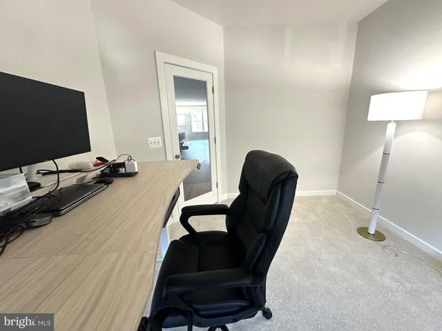 a view of a workspace with furniture and a flat screen tv
