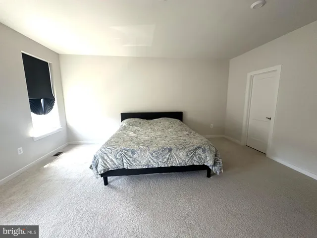 a bedroom with a bed tv and couch