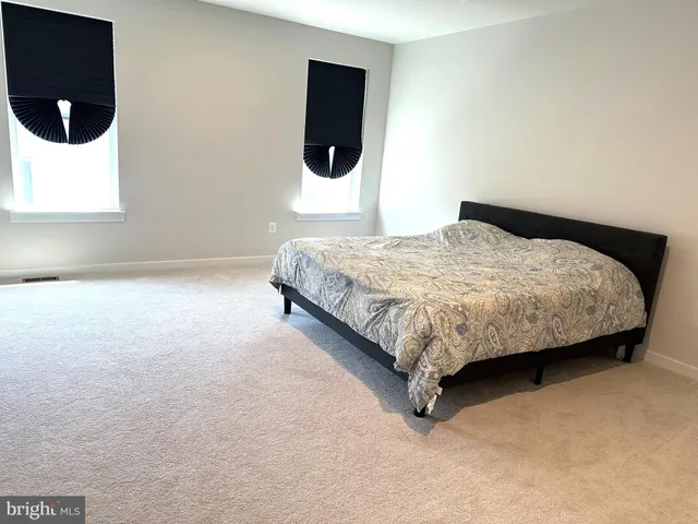 a bed sitting in a bedroom next to a window