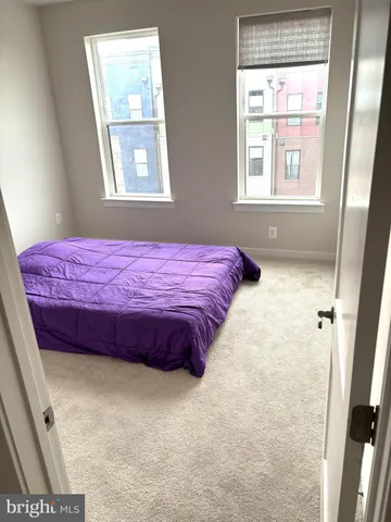 a bed sitting in a bedroom next to a window