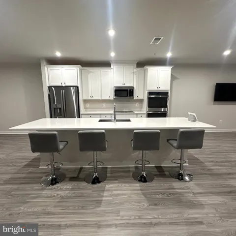 a kitchen with a sink counter and chairs