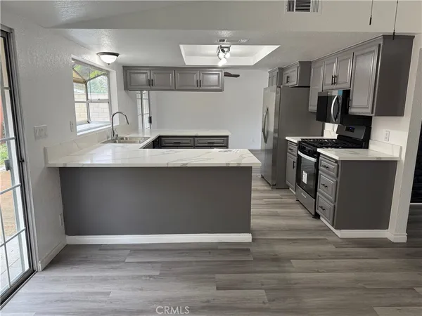 a kitchen with stainless steel appliances granite countertop a sink stove and refrigerator