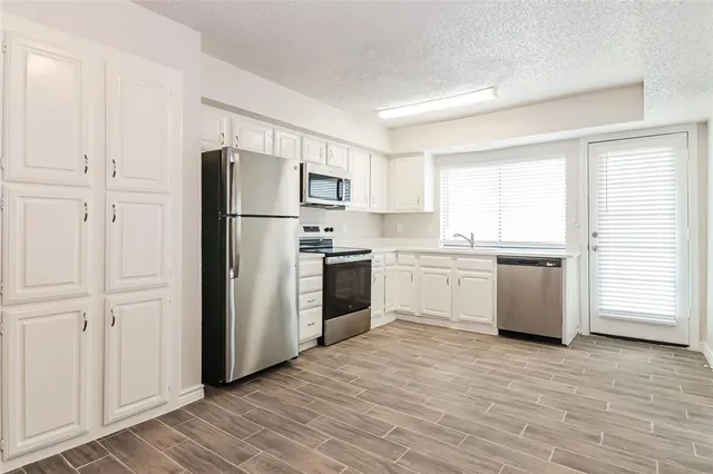 a kitchen with white cabinets and white stainless steel appliances