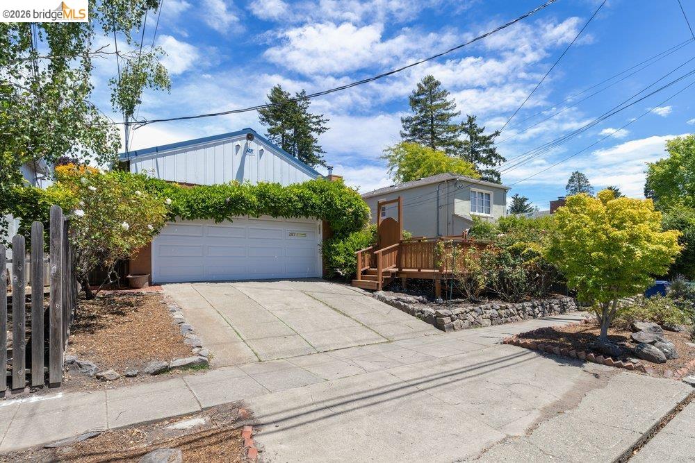 287 Purdue Avenue Kensington, CA 94708 - Photo 2 of 60 Property exterior featuring a two-car garage with a concrete driveway, a wooden deck, and established landscaping