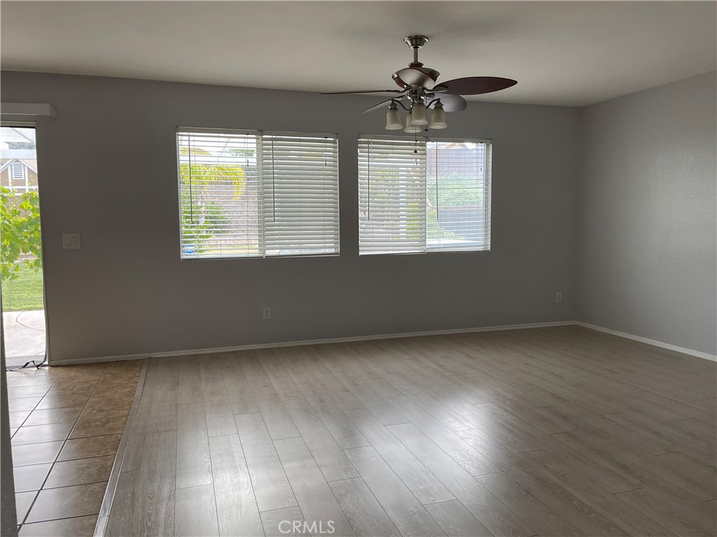 38017 Greenleaf Place Murrieta, CA 92562 - Photo 18 of 37 an empty room with wooden floor chandelier and windows