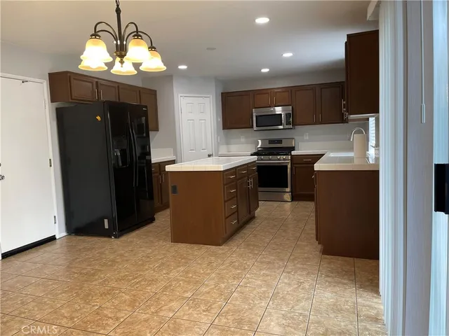 a kitchen with stainless steel appliances granite countertop a refrigerator and a stove top oven
