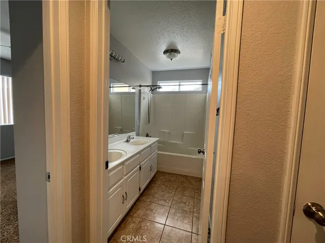 a bathroom with a tub shower and sink