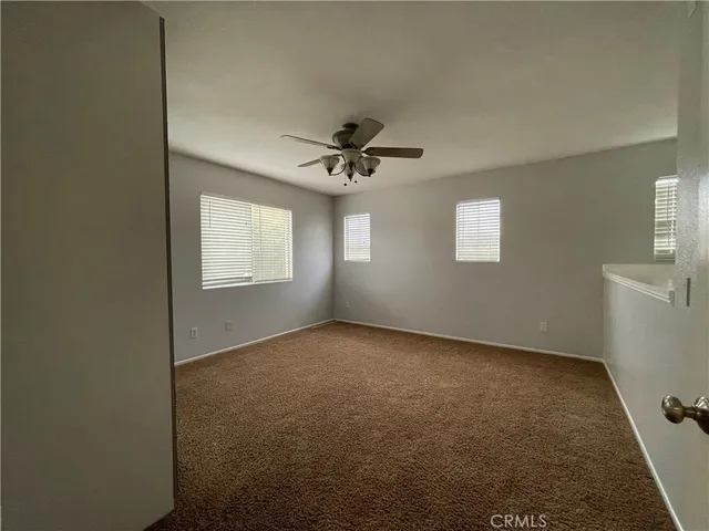 a view of a livingroom with a ceiling fan and window
