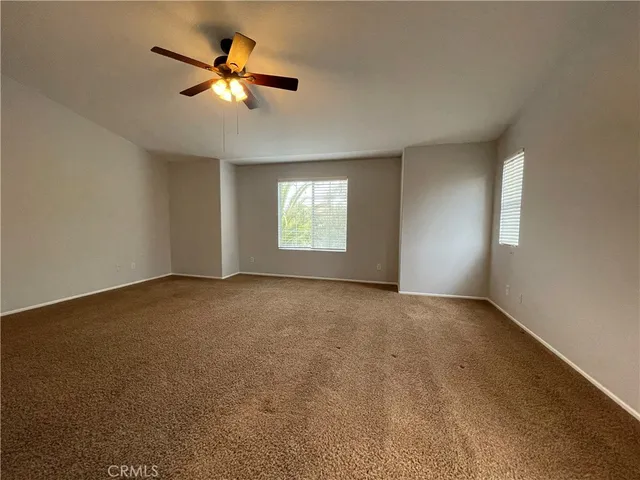 a view of a livingroom with a ceiling fan and window
