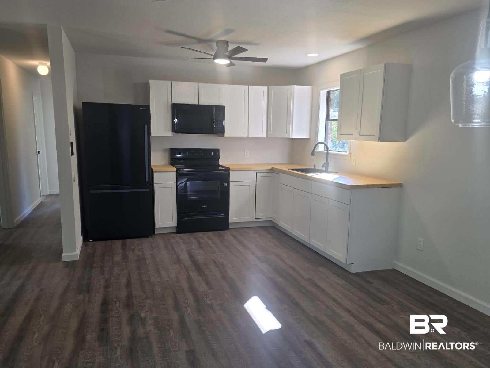 1404 Dailey Street Brewton, AL 36426 - Photo 8 of 25 Kitchen with black appliances, light countertops, white cabinetry, dark wood-style flooring, and a ceiling fan