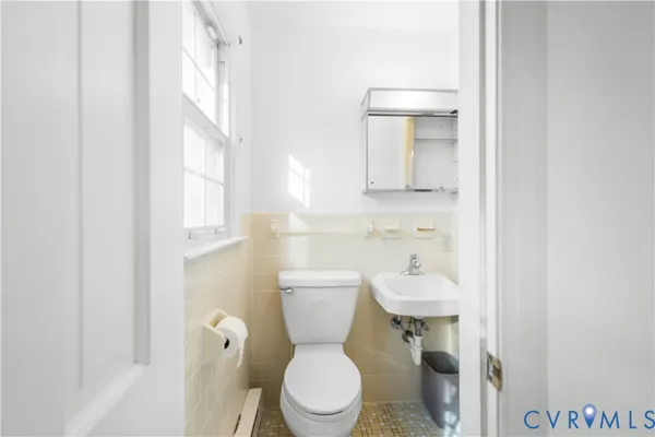 a bathroom with a sink a toilet and mirror