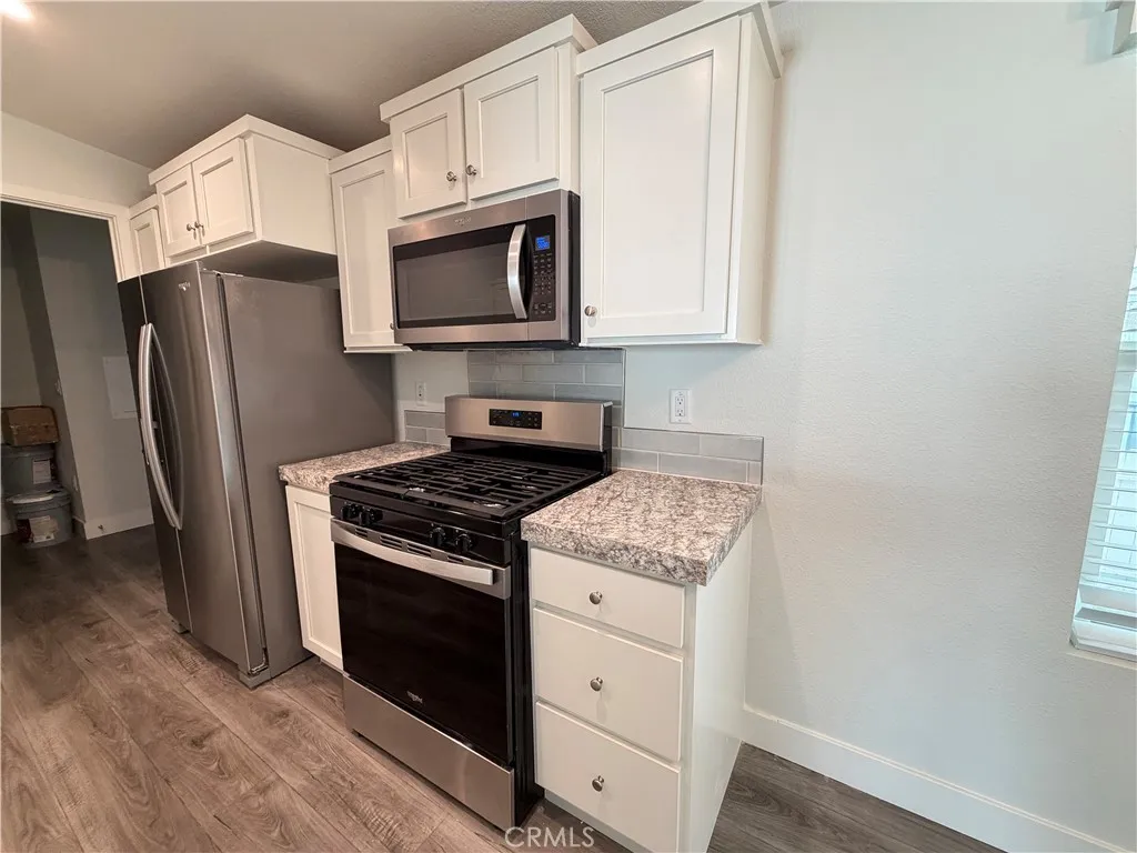 9080 Bloomfield Avenue, Unit 145 Cypress, CA 90630 - Photo 11 of 26 a kitchen with stainless steel appliances white cabinets and a stove top oven