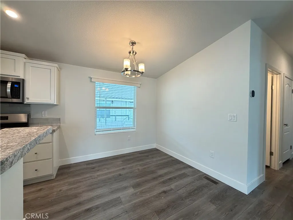 9080 Bloomfield Avenue, Unit 145 Cypress, CA 90630 - Photo 12 of 26 a view of a kitchen with dishwasher and wooden floor