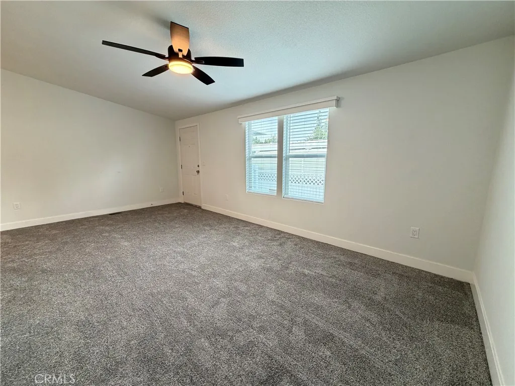 9080 Bloomfield Avenue, Unit 145 Cypress, CA 90630 - Photo 14 of 26 an empty room with ceiling fan and windows