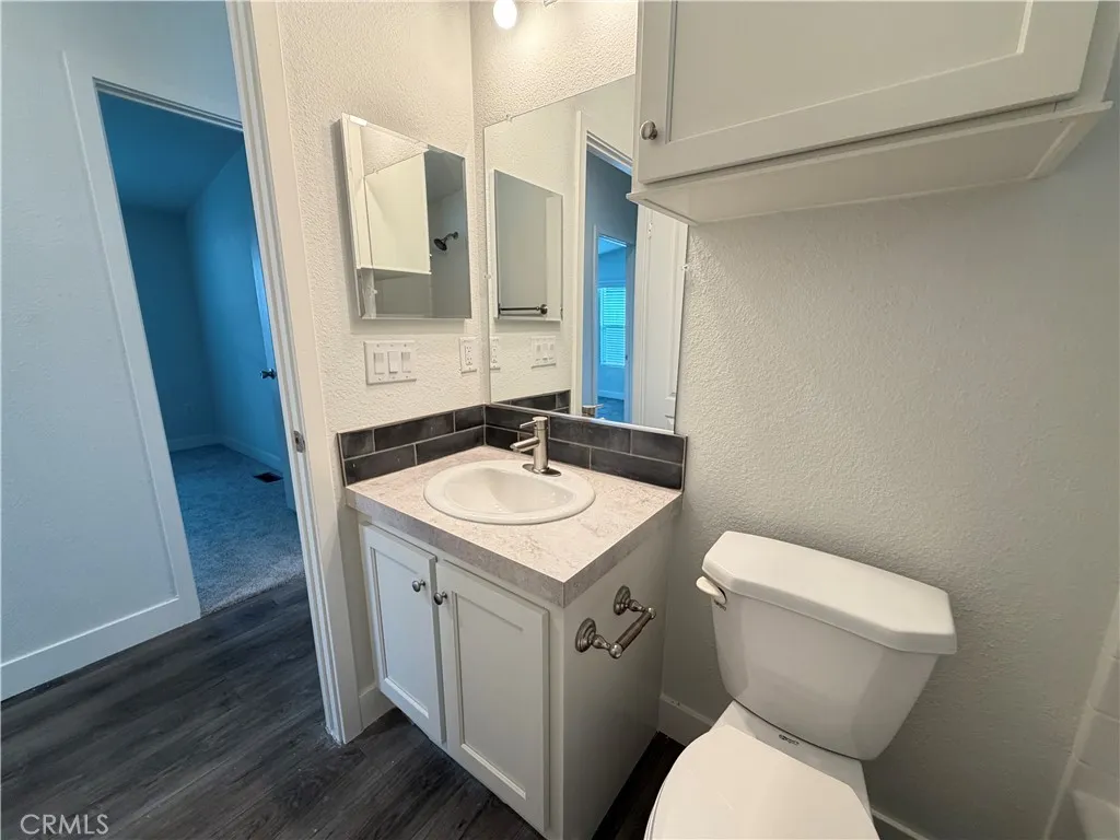 9080 Bloomfield Avenue, Unit 145 Cypress, CA 90630 - Photo 21 of 26 a bathroom with a granite countertop toilet sink and mirror