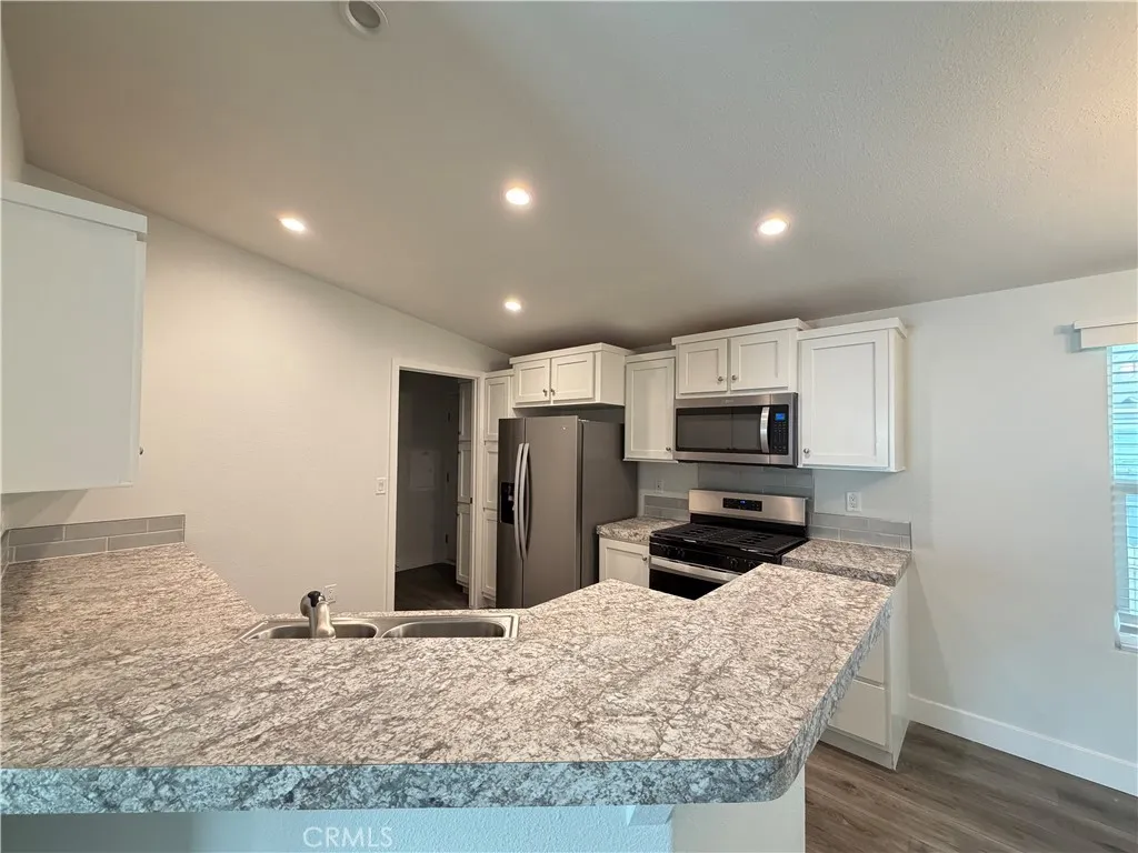 9080 Bloomfield Avenue, Unit 145 Cypress, CA 90630 - Photo 6 of 26 a kitchen with stainless steel appliances granite countertop a refrigerator and a sink