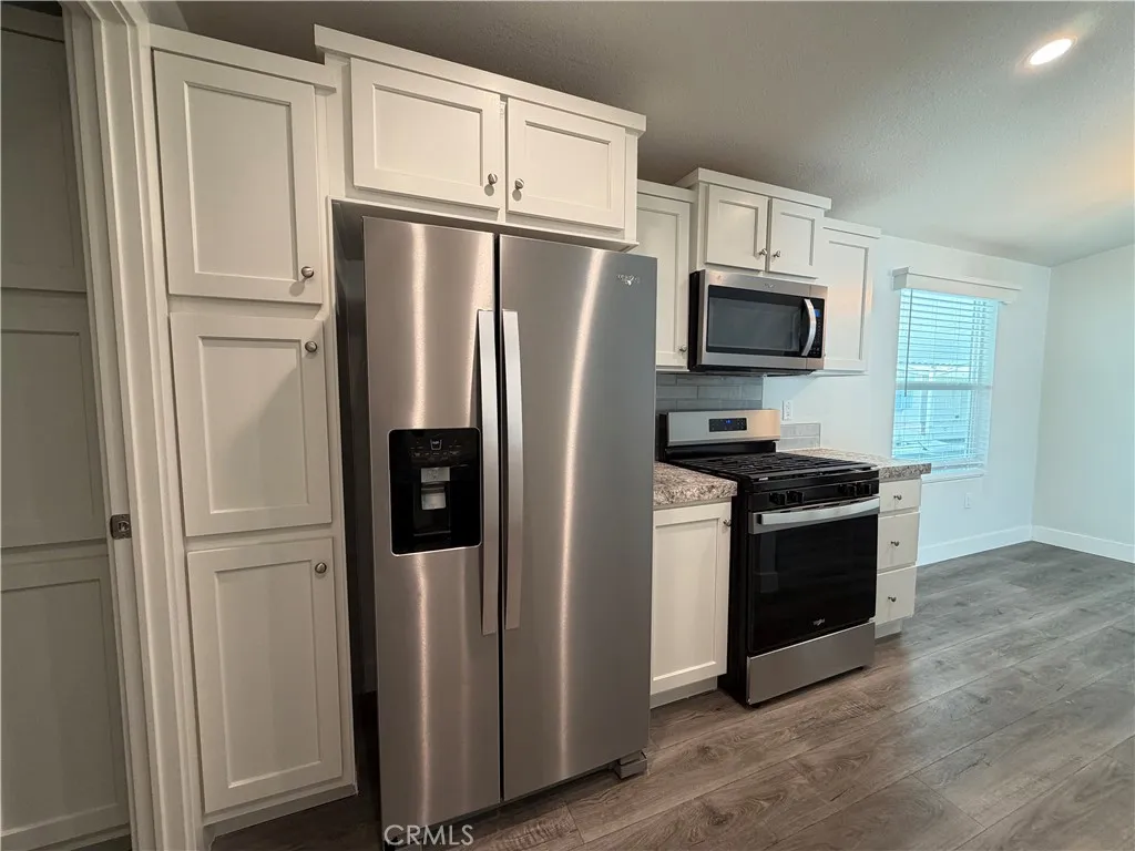 9080 Bloomfield Avenue, Unit 145 Cypress, CA 90630 - Photo 8 of 26 a kitchen with stainless steel appliances granite countertop a refrigerator stove and microwave
