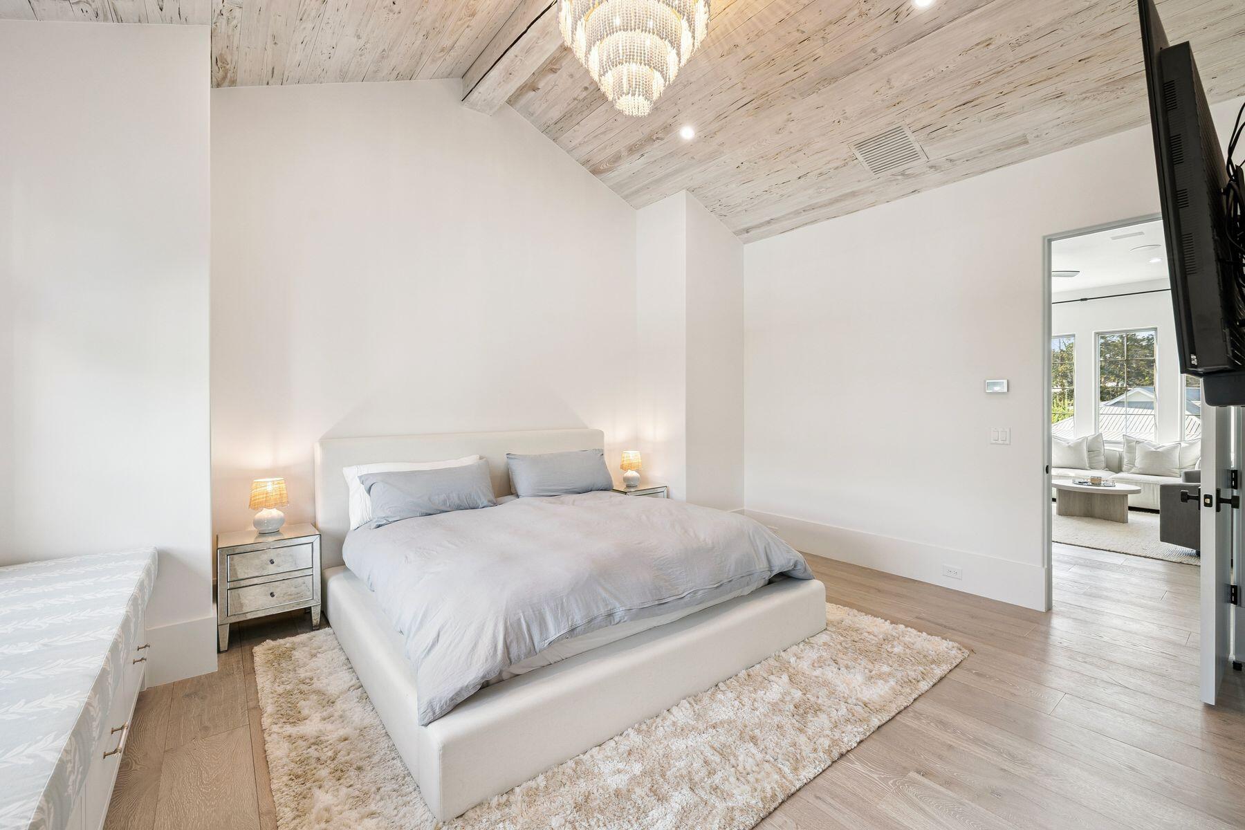215 Dogwood Street Santa Rosa Beach, FL 32459 - Photo 58 of 91 a bedroom with a large bed and a chandelier