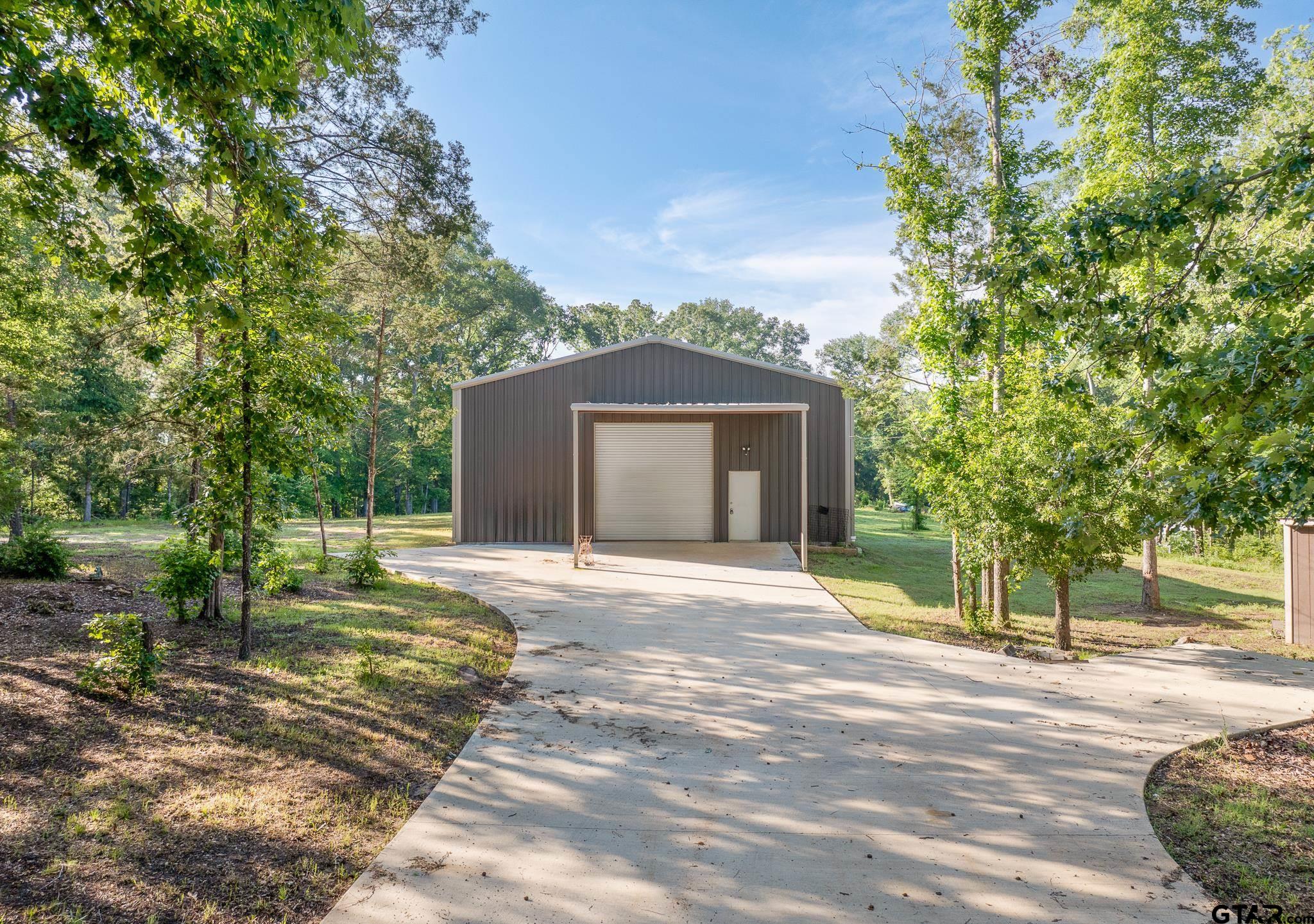 a front view of a house with a garden and trees
