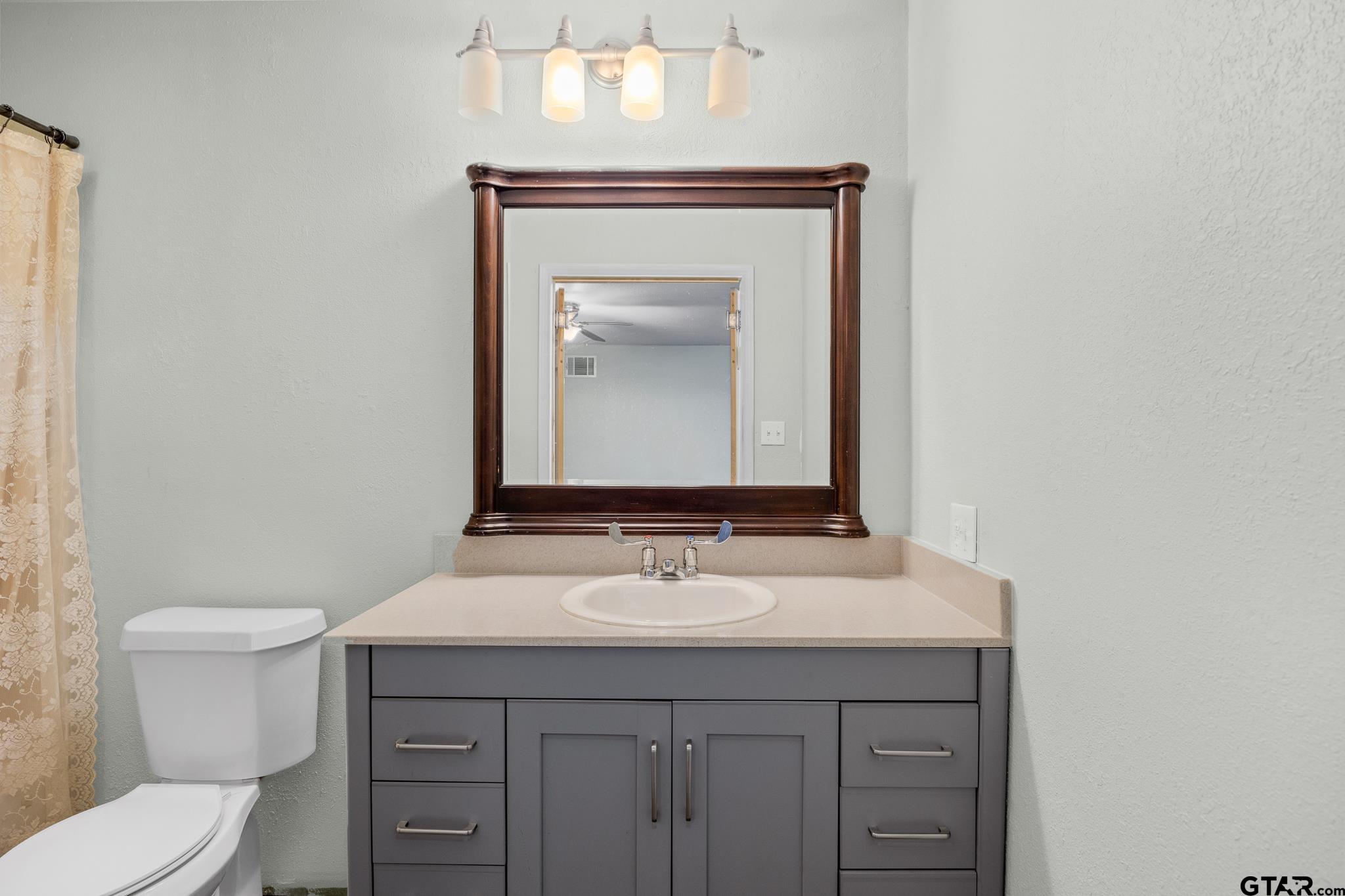 1428 Hagan Road Whitehouse, TX 75791 - Photo 14 of 37 a bathroom with a toilet sink and mirror