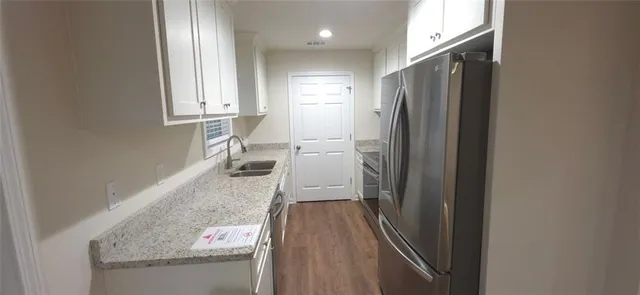 a kitchen with granite countertop a refrigerator and a sink