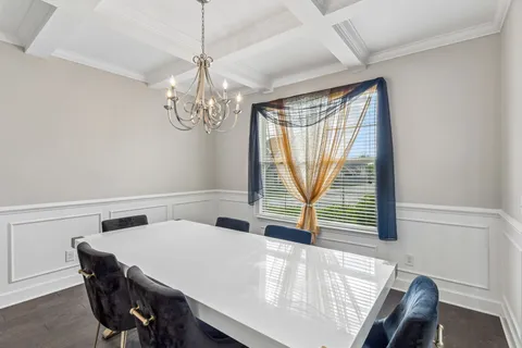 a dining room with wooden floor and a chandelier