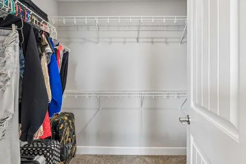 a view of walk in closet with clothes