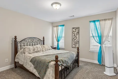 a bedroom with a bed next to a window