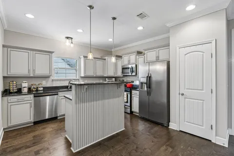 a kitchen with stainless steel appliances granite countertop a refrigerator a sink and a stove