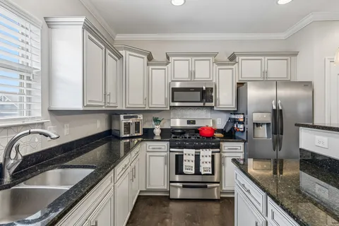a kitchen with stainless steel appliances granite countertop a sink stove and refrigerator