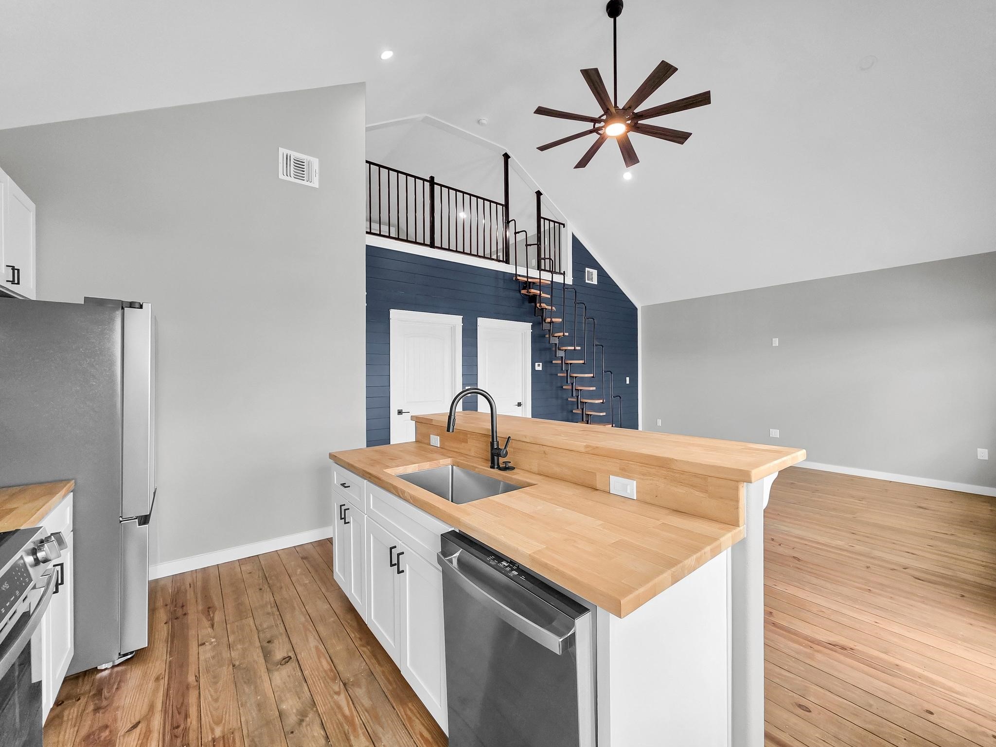 1041 Sunset Circle Crystal Beach, TX 77650 - Photo 19 of 45 a open kitchen with stainless steel appliances granite countertop a sink a refrigerator and a stove with wooden floor