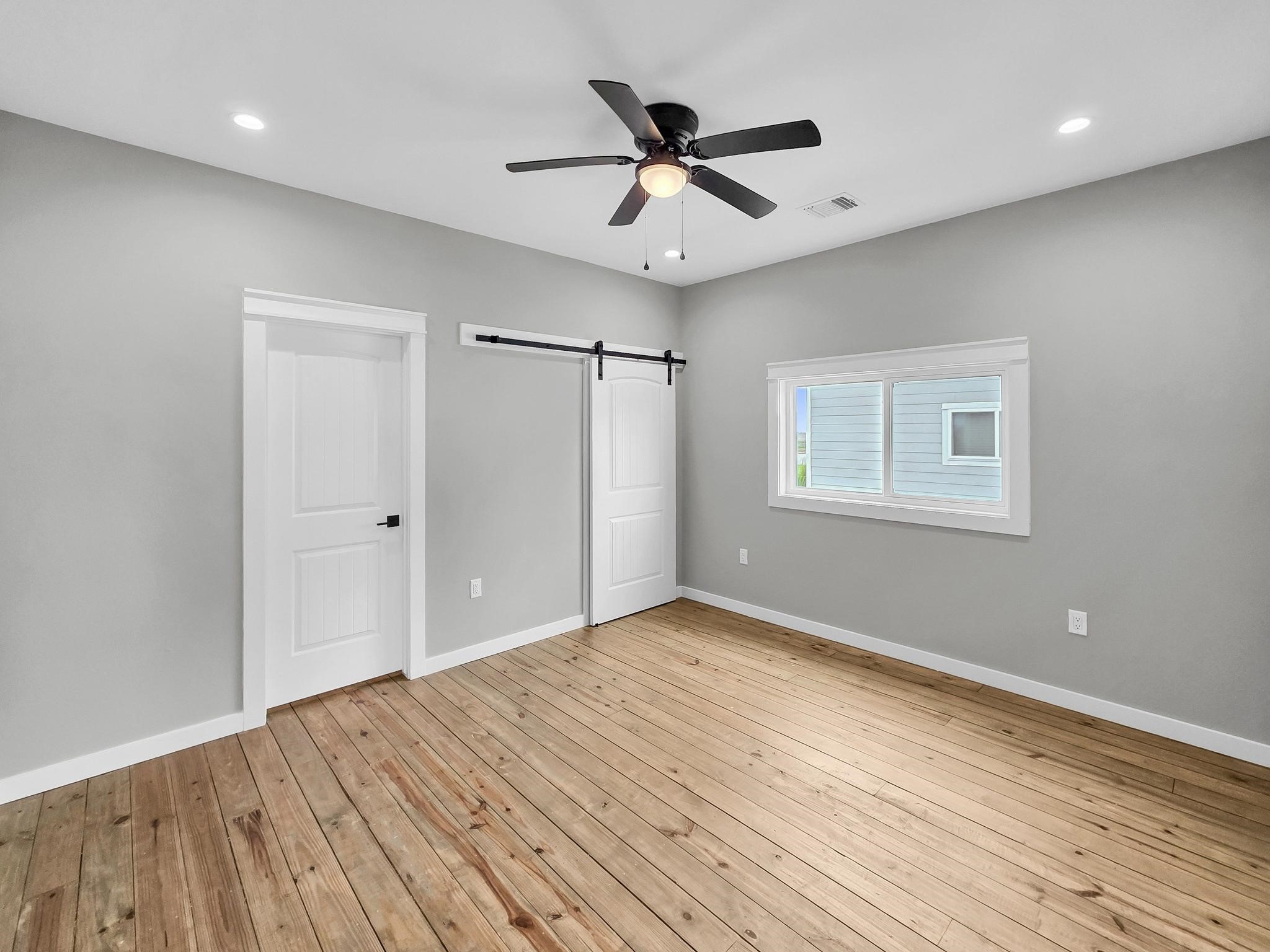 1041 Sunset Circle Crystal Beach, TX 77650 - Photo 30 of 45 a view of an empty room with wooden floor and a ceiling fan