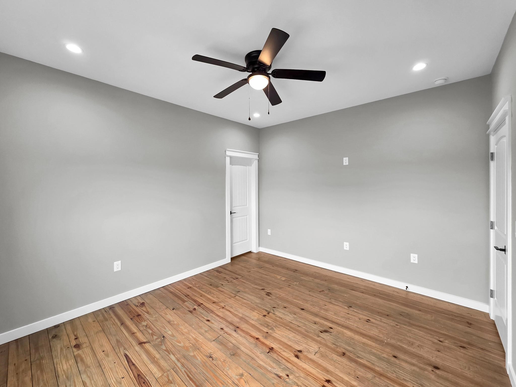 1041 Sunset Circle Crystal Beach, TX 77650 - Photo 36 of 45 an empty room with wooden floor and ceiling fan