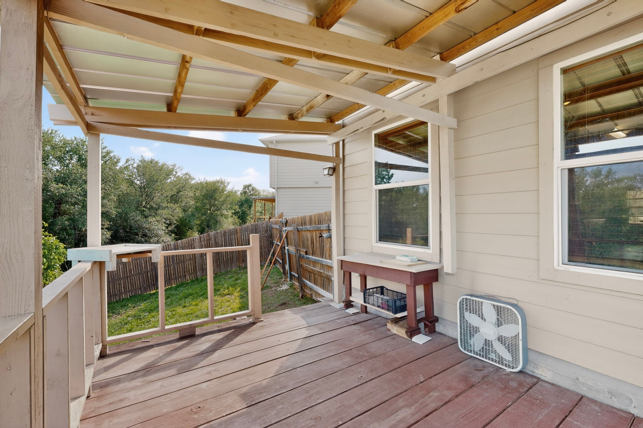 5905 Diamondleaf Bend Austin, TX 78724 - Photo 33 of 38 Covered outdoor deck with wood-finish flooring, featuring a slatted railing and a partial privacy fence