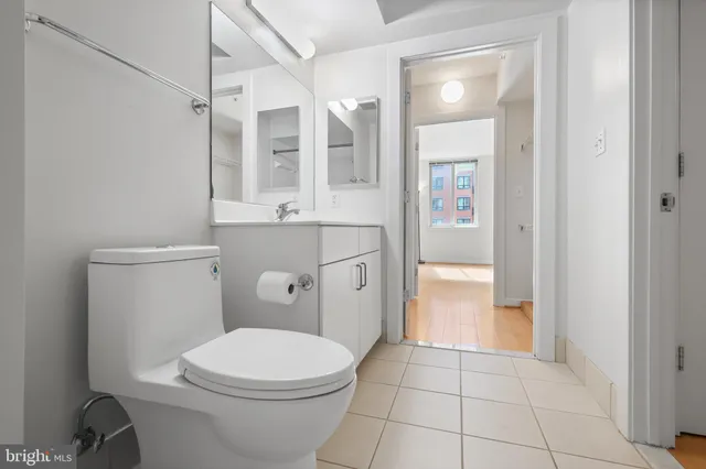 a bathroom with a granite countertop toilet sink and mirror