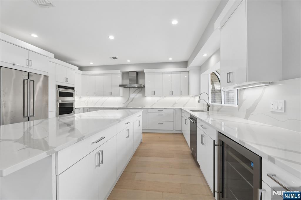 1225 River Road, Unit 4D Edgewater, NJ 07020 - Photo 12 of 47 a large white kitchen with stainless steel appliances and a sink