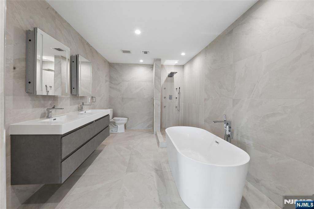 1225 River Road, Unit 4D Edgewater, NJ 07020 - Photo 26 of 47 a spacious bathroom with a double vanity sink mirror and a bathtub