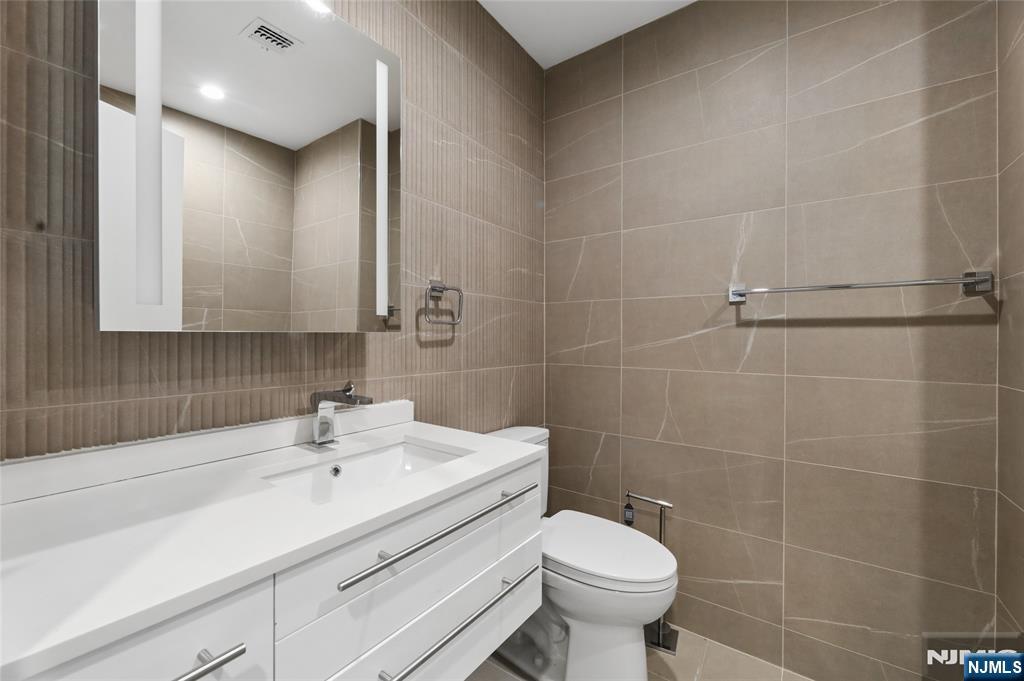 1225 River Road, Unit 4D Edgewater, NJ 07020 - Photo 32 of 47 a bathroom with a sink toilet and a mirror